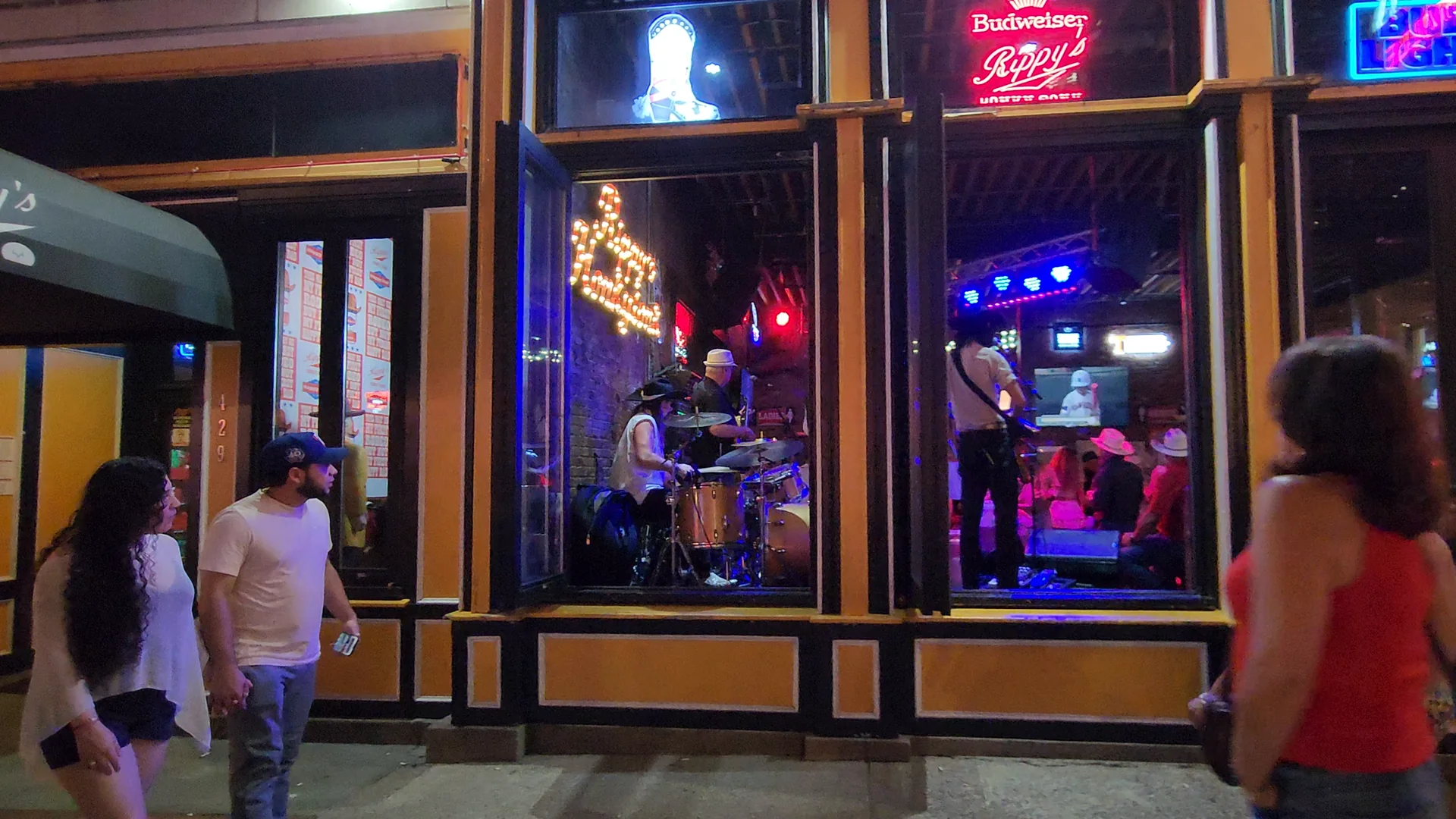 Live musicians visible through the windows of a Lower Broadway bar.